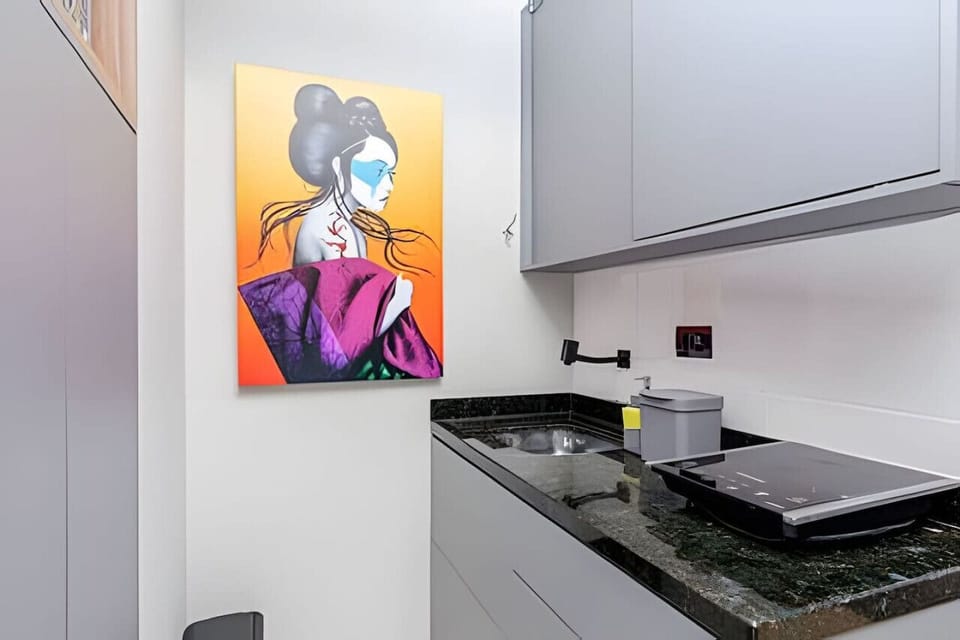 Cozinha - pia, armários e cooktop.
