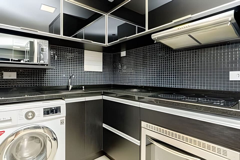 Cozinha - Micro-ondas, máquina de lavar, exaustor, forno, pia e cooktop de 4 bocas.
