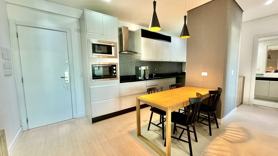 Cozinha branca com bancada amarela e sofa preto integrado