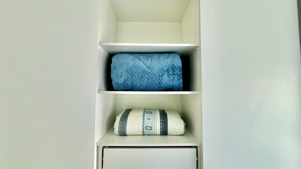 Nichos com toalhas dobradas e produtos de higiene bem organizados