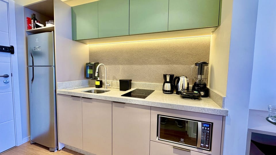 Cozinha com geladeira duplex, cafeteira, chaleira, liquidificador e micro-ondas