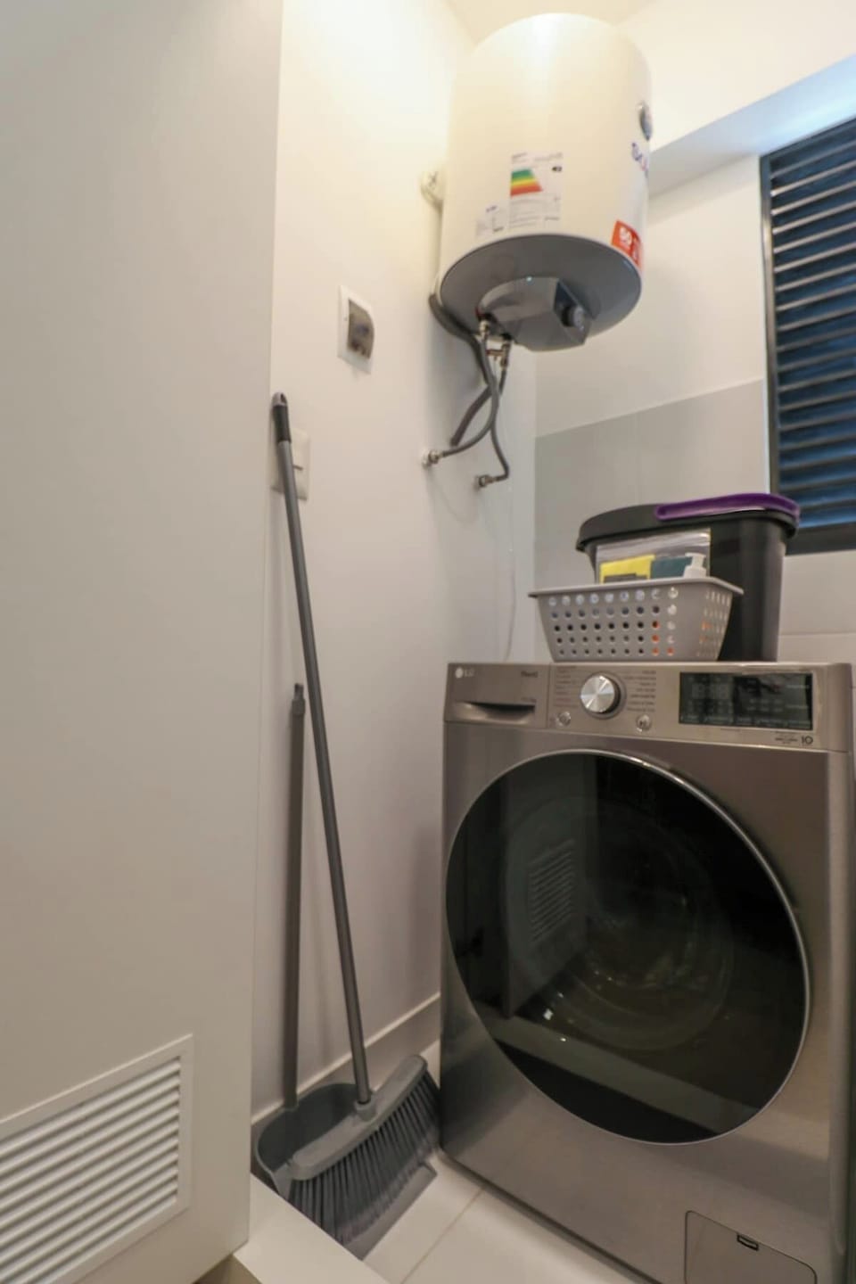 Laundry area with washing machine and cleaning supplies