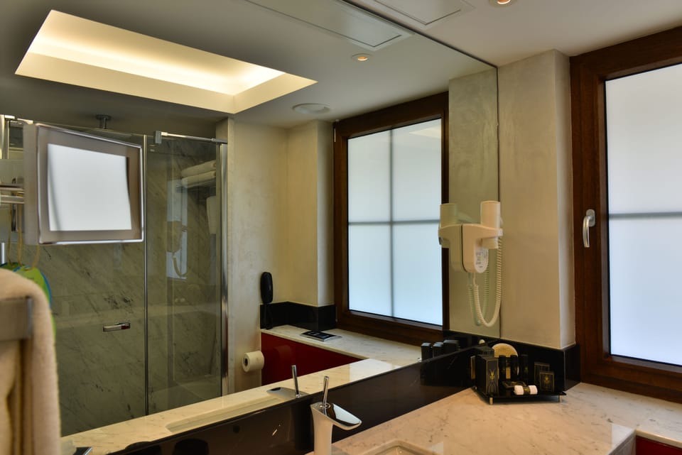Executive Deluxe King Room | Bathroom | Designer toiletries, hair dryer, slippers, towels