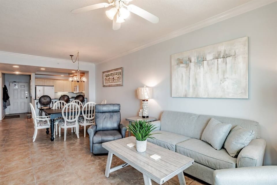 Living area features sleeper sofa, flat screen smart tv, recliner, arm chair and glass sliding doors leading to the private balcony with beachfront ocean views.
