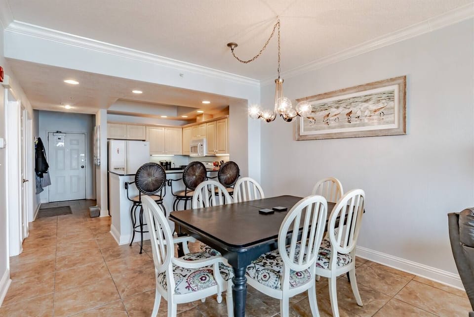 Dining area with table and 6 chairs and bar seating for 3