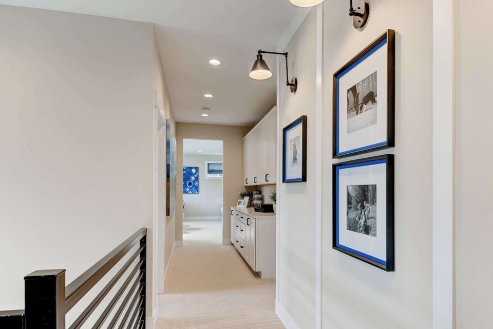 This open stairwell floods with natural light and features striking wall art for an elevated first impression.