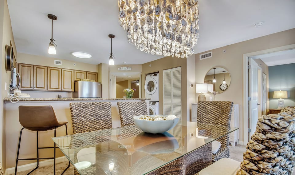 Your elegant dining space flows seamlessly into the gourmet kitchen, where warm earth tones and crystal chandelier create perfect ambiance for memorable meals.