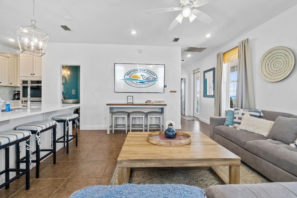 Relax in this bright open-concept living space where coastal charm meets modern comfort, complete with cozy seating and natural light.