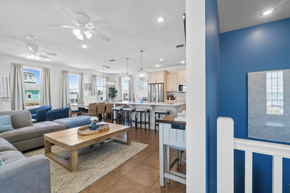 Your spacious open-concept retreat flows from cozy living to modern kitchen, where coastal blues and warm furnishings create the perfect beach house vibe.