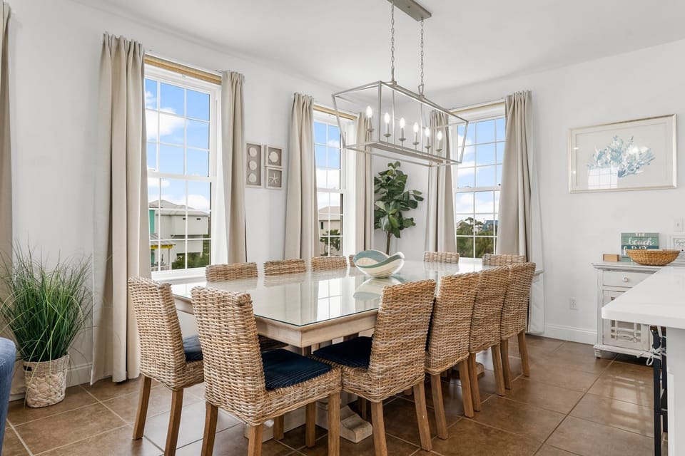 Gather around this elegant dining table where natural light streams through three windows, creating the perfect setting for memorable meals together.