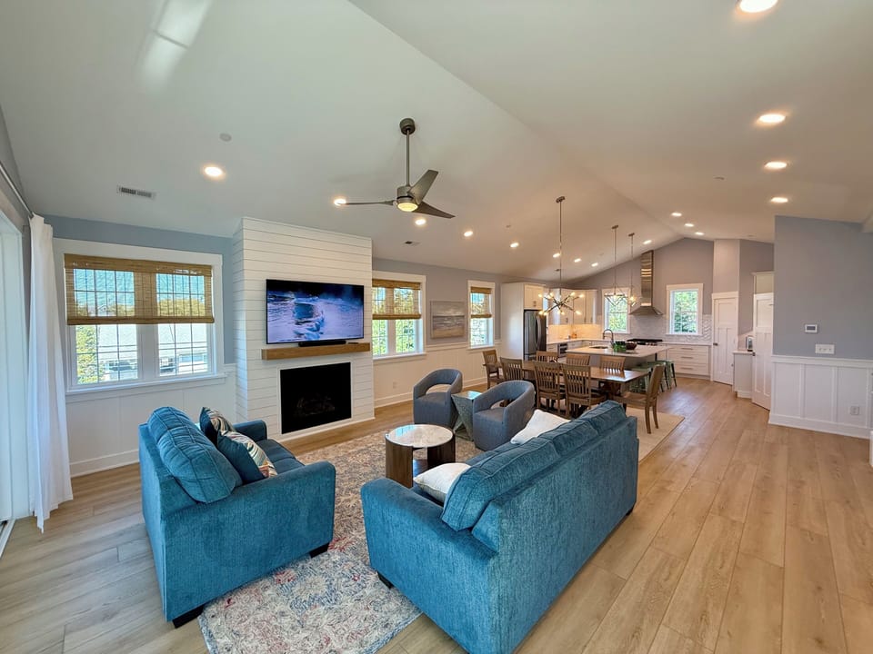 Living room with cathedral ceiling looking into dining area