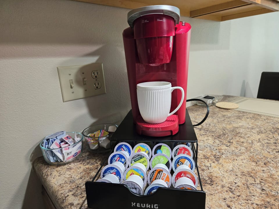 coffee station with coffees, teas, and hot chocolate, creamers and sugars