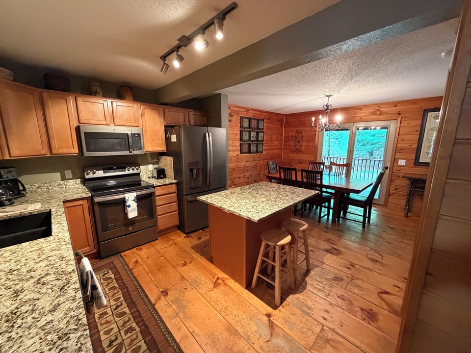 Picture yourself preparing meals in this spacious, fully-equipped kitchen with gleaming granite countertops and modern appliances, then gathering with loved ones at the adjacent dining table to share stories and laughter.