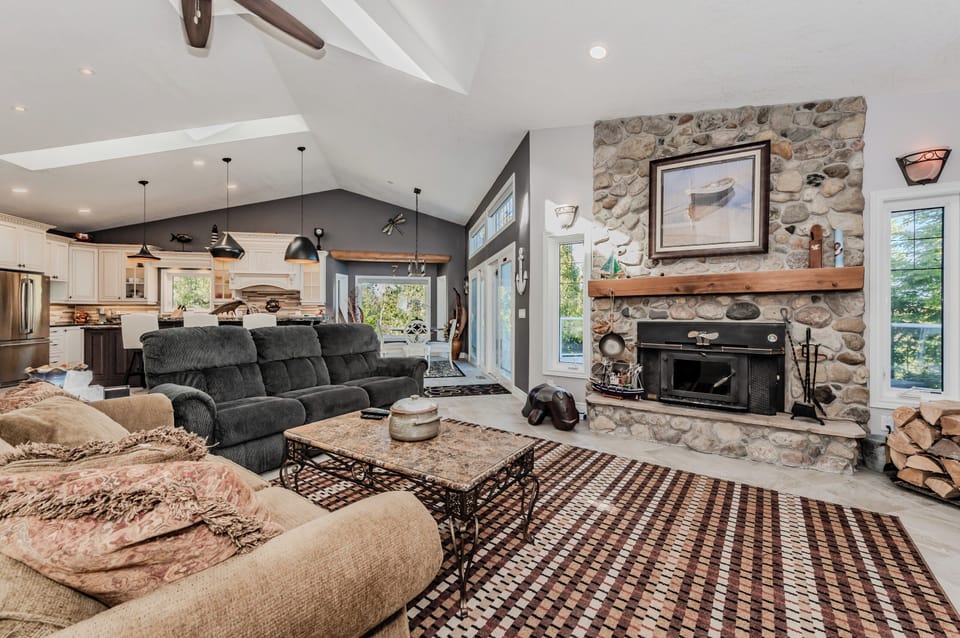 Relax fireside in this cozy, rustic-chic vacation rental. With a stone hearth, comfy seating, and open-concept flow, it's the perfect retreat after lakeside adventures or forest hikes.
