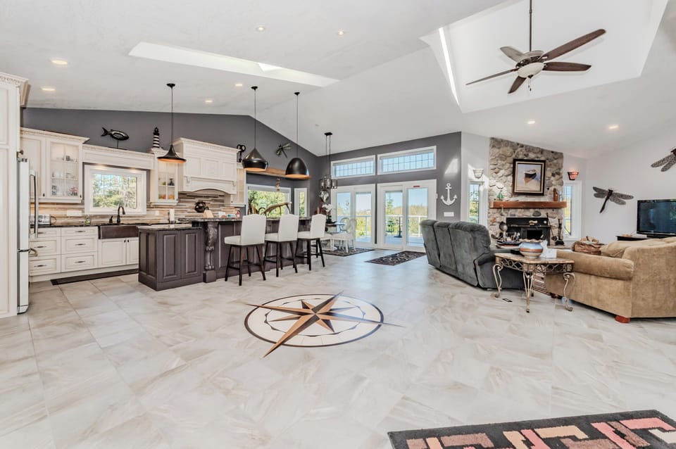 Spacious and stylish lakeside getaway with vaulted ceilings, skylights, and a custom compass inlay. A perfect blend of comfort and charm for family vacations or group retreats.