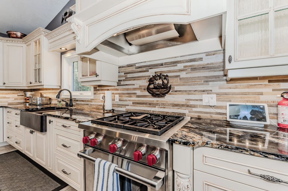 Cook like a pro in this chef’s kitchen featuring a high-end gas range, elegant finishes, and rustic-modern style—ideal for culinary-inspired getaways or family meals in the forest.