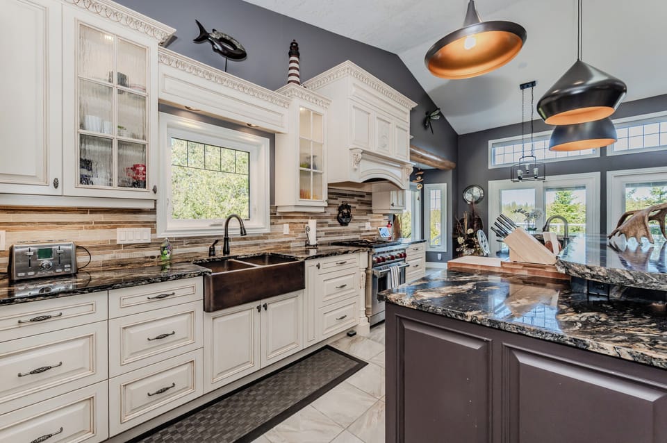Enjoy gourmet cooking in this stunning vacation rental kitchen, featuring granite counters, high-end appliances, and panoramic views—perfect for culinary getaways or cozy cottage escapes.