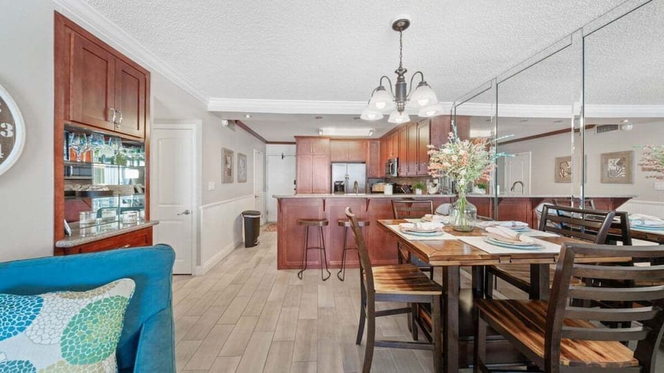 Dining area with mirrored wall, warm lighting, and bar seating for easy meals and entertaining.