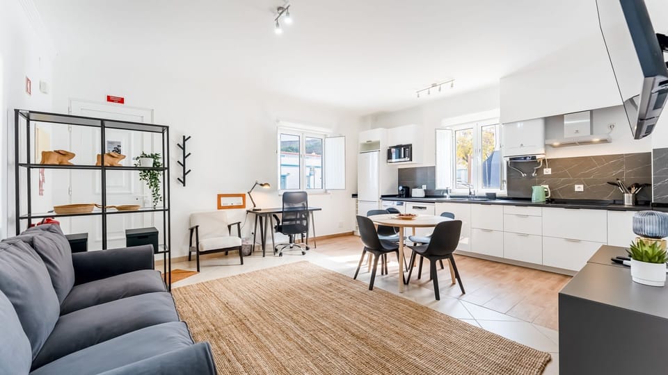 Spacious open-plan area with a cozy lounge, full kitchen, and dedicated workspace.
#WorkAndStay #OpenPlanLiving #RemoteWorkReady #PortugalRental #CityLiving #LovelyStay