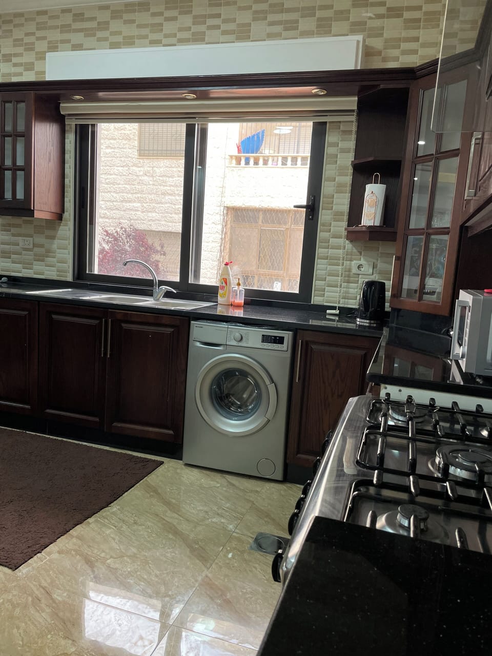 well equipped kitchen with washing machine, gas stove, fridge, microwave, kettle