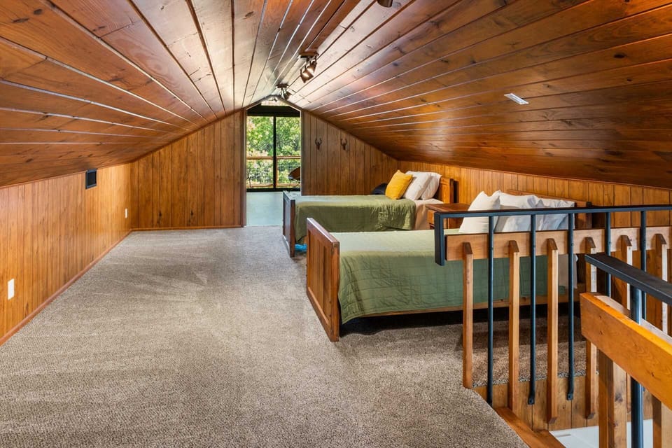 Cozy loft with twin beds and wood-paneled charm-perfect for kids or extra guests in this warm, inviting retreat.