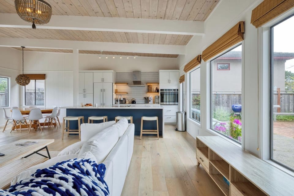 - Open living and kitchen layout with vaulted ceilings and wood flooring  
- Large windows overlook the courtyard, filling the space with sunlight  
- Kitchen island with bar seating is perfect for casual dining or drinks  
