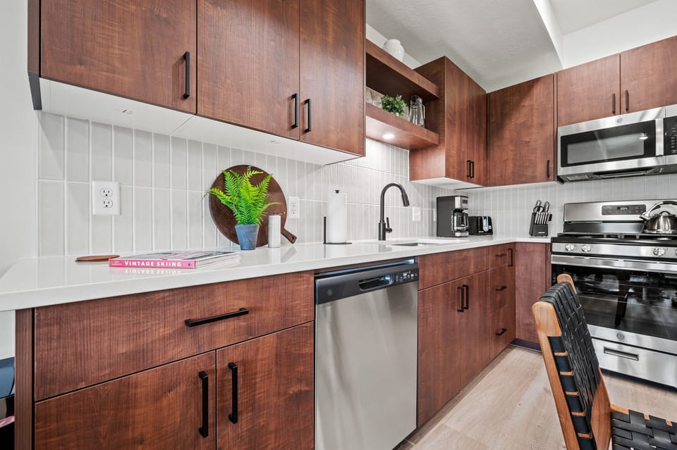 With its modern lighting, windows, quartz countertops, and stunning backsplash, the kitchen makes preparing dinner a truly enjoyable experience.