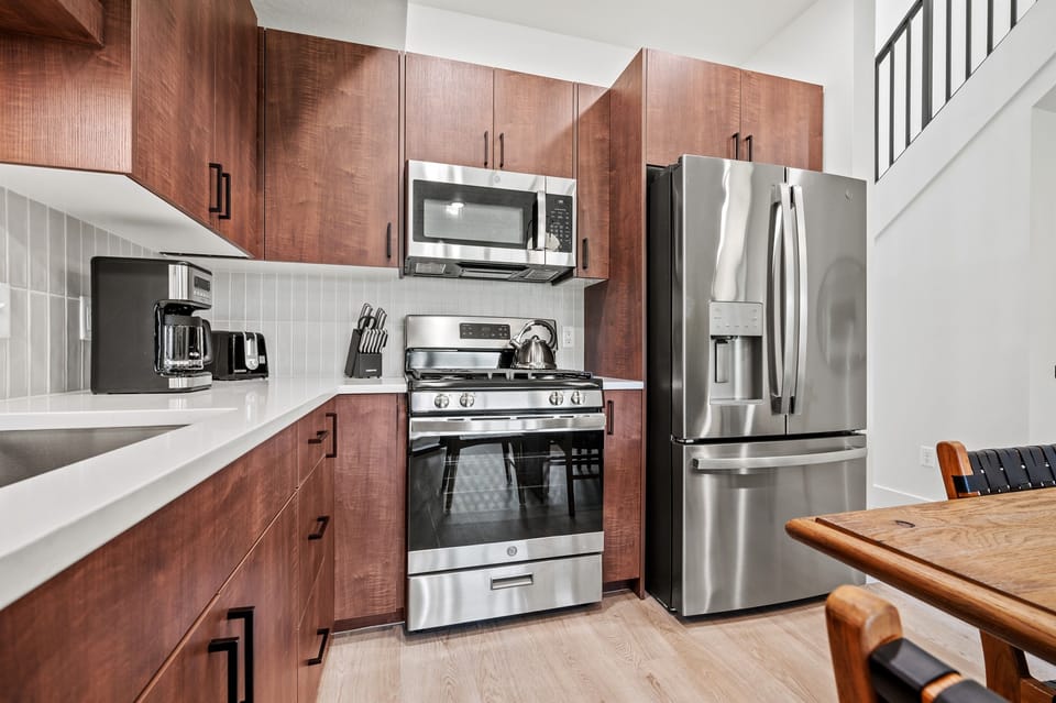 The gourmet kitchen is equipped with appliances, including a microwave, gas stove, and spacious refrigerator.