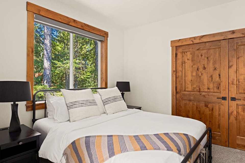 Bedroom 1: King - A little slice of forest fantasy! Our bedroom offers the perfect blend of rustic charm and modern comfort. The stunning wood doors and window trim complement the serene view of the forest, making it a peaceful and private sanctuary.