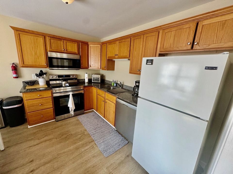 Kitchen with new appliance, ice maker, and sitting area.
