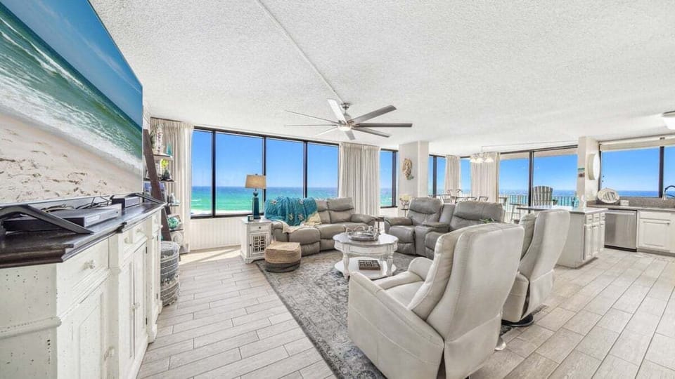 Spacious, light-filled living room with Gulf views, plush leather seating, and coastal chic design—flows into dining and kitchen areas for easy entertaining.