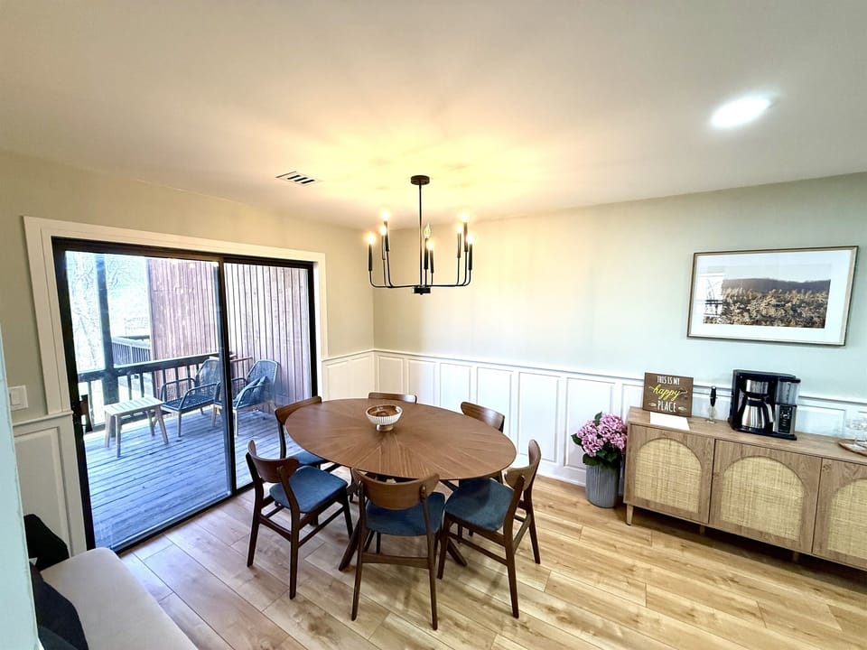 Gather around the dining table with seating for up to 8, opening onto the balcony for fresh air and treetop views. A nearby buffet makes serving meals—or morning coffee—a breeze.