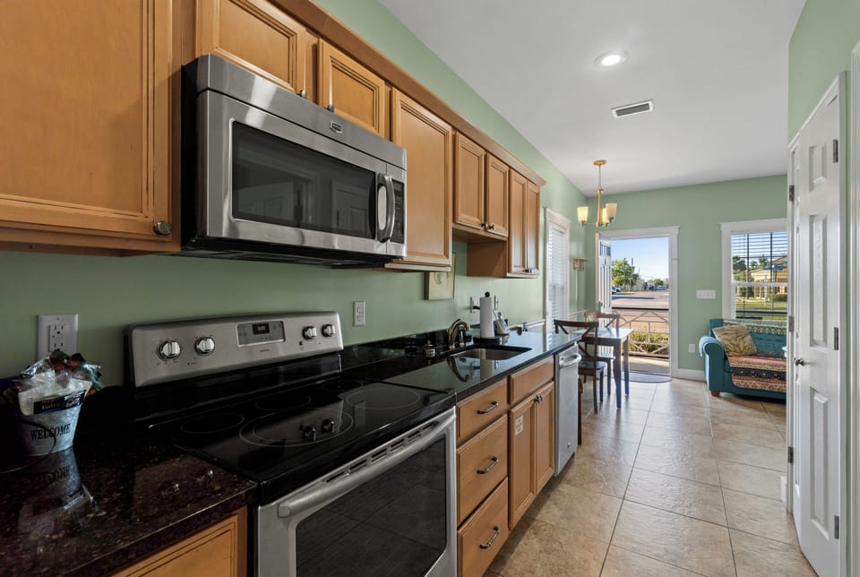 Your fully equipped kitchen features modern stainless steel appliances and warm wood cabinetry, perfect for preparing meals during your stay.