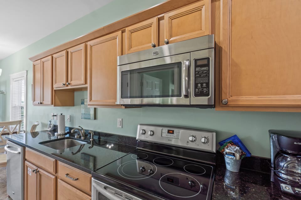 Your fully equipped kitchen features granite countertops, stainless steel appliances, and warm wood cabinetry for preparing memorable meals during your stay.
