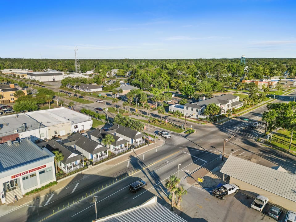 Aerial view of a charming Florida neighborhood with tree-lined streets, local businesses, and easy access to amenities.