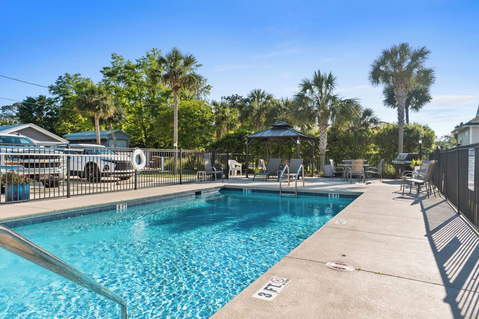 Dive into your private oasis with crystal-clear waters surrounded by swaying palms and comfortable lounge chairs for ultimate relaxation.
