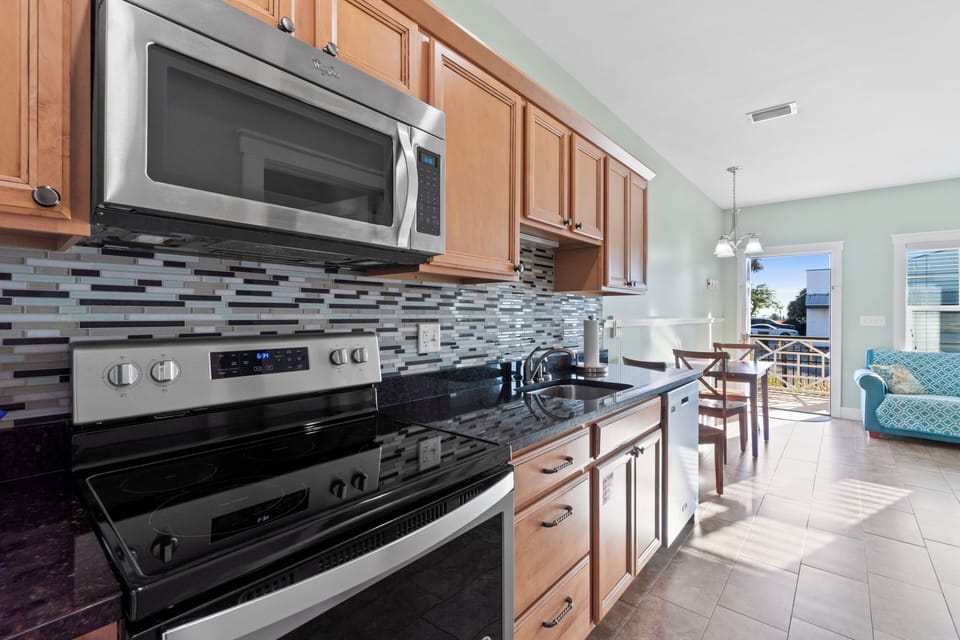 Your fully equipped kitchen features granite counters, stainless appliances, and opens to your sunny living space with balcony access.