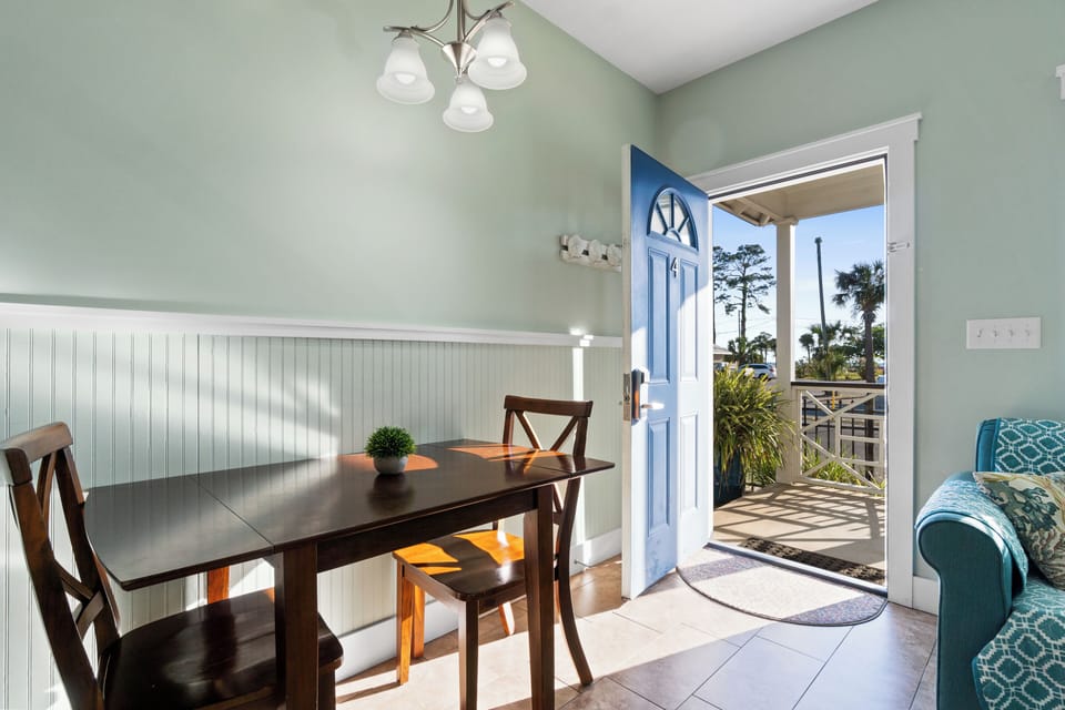 Your coastal dining area features warm wood furnishings and opens to a private balcony where palm trees sway in the gentle breeze.