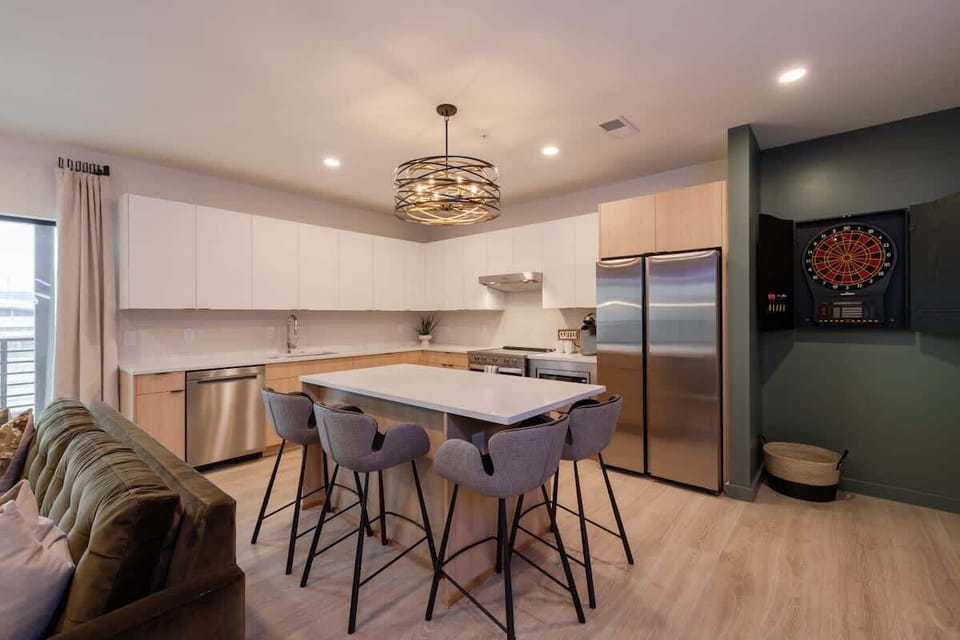 Open-concept kitchen with modern appliances, stylish lighting fixture, and a cozy seating area perfect for entertaining.