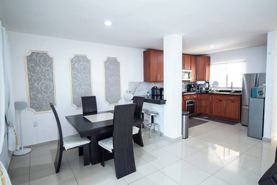 The dinning room is equipped with 4 chair and a family table, SONOS speakers and two bar chairs 