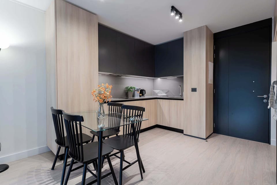 Experience modern living in this stylish kitchen, featuring sleek cabinetry and a cozy dining area perfect for meals and gatherings.