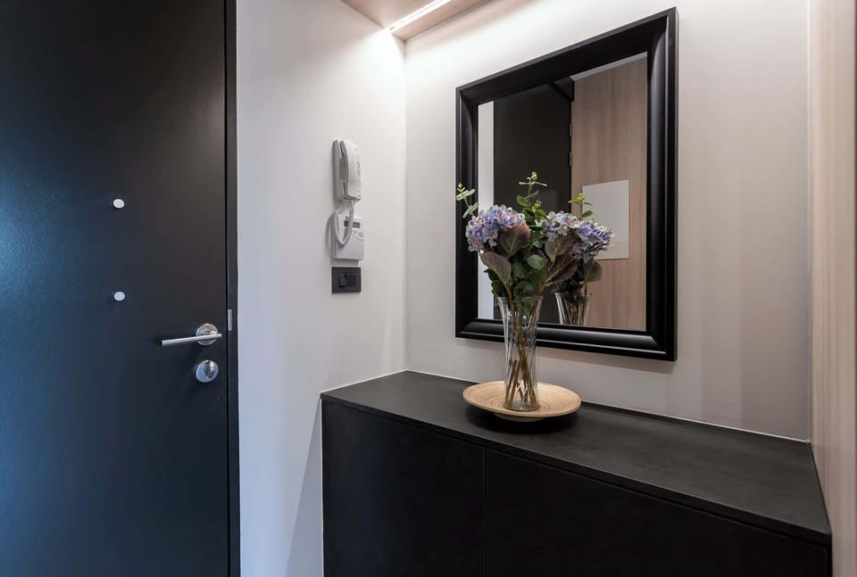 Welcome to your stylish entryway, featuring a modern design and a touch of nature with fresh flowers.