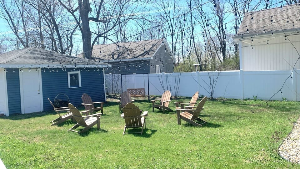Backyard with adirondack chairs and grassy lawn