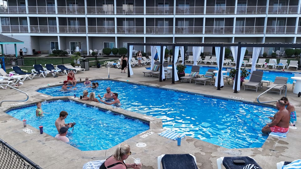 Guests enjoy the inviting outdoor pool area, complete with cabanas and comfortable loungers—perfect for soaking up the sun and relaxing by the water.