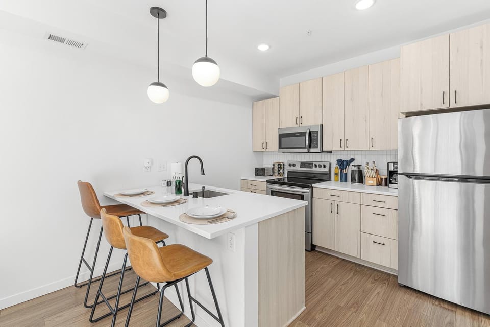 Bright modern kitchen with island seating and stainless steel appliances
