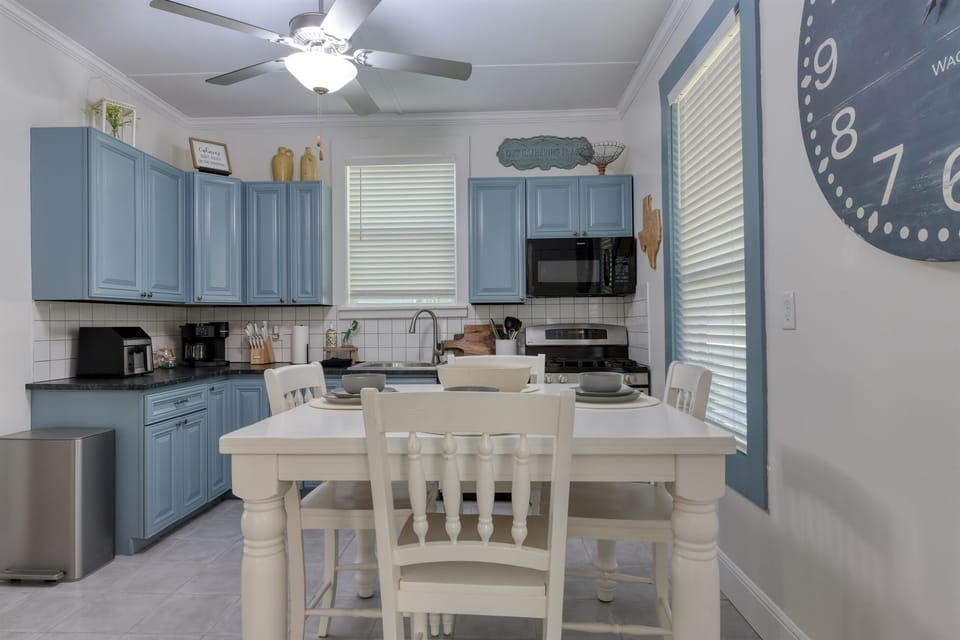The fully furnished kitchen is equipped with dishes, utensils, and appliances.
