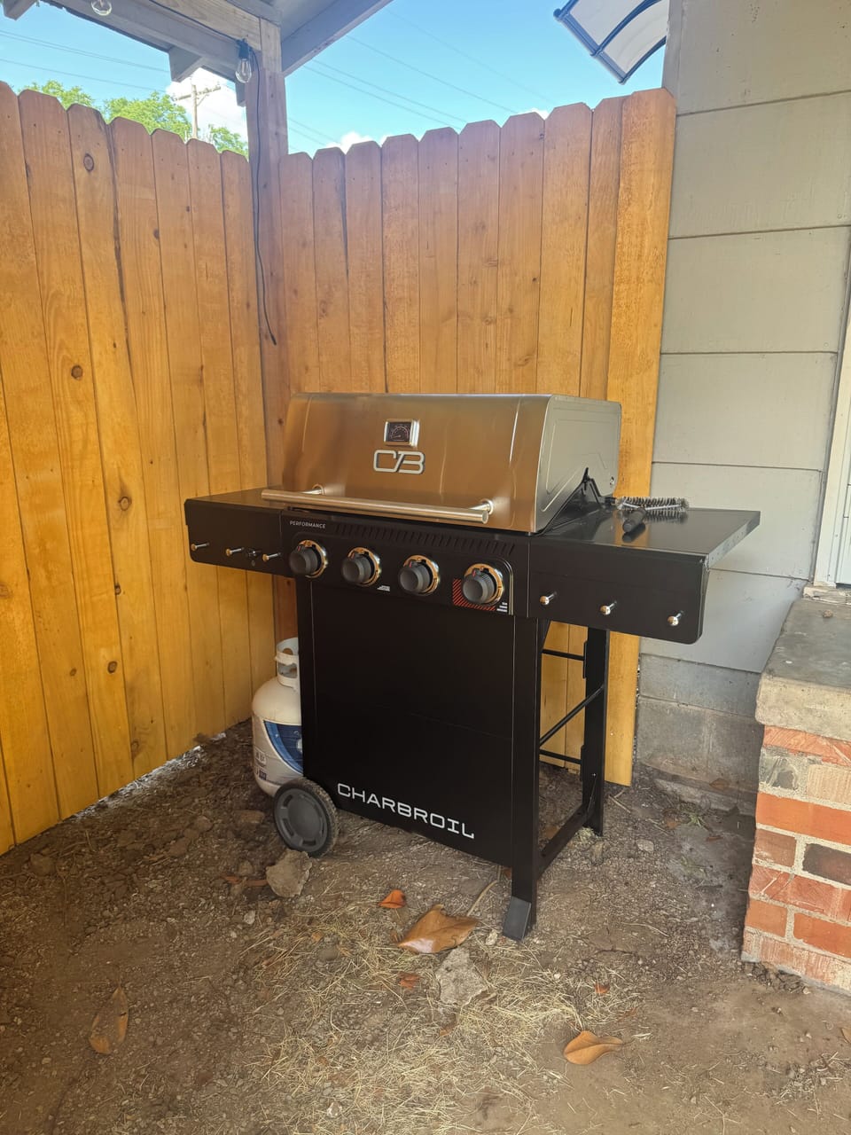 Gas grill with picnic table under awning. 