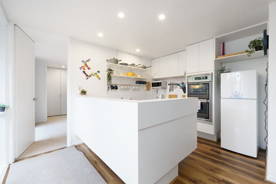 Thoughtfully styled kitchen with open shelving for colorful mugs and cookware, plus a unique all-in-one oven for every meal.