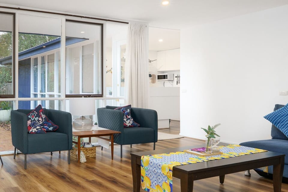 Relax in the vibrant living area with a navy blue couch and a vintage-style smart TV that doubles as art.
