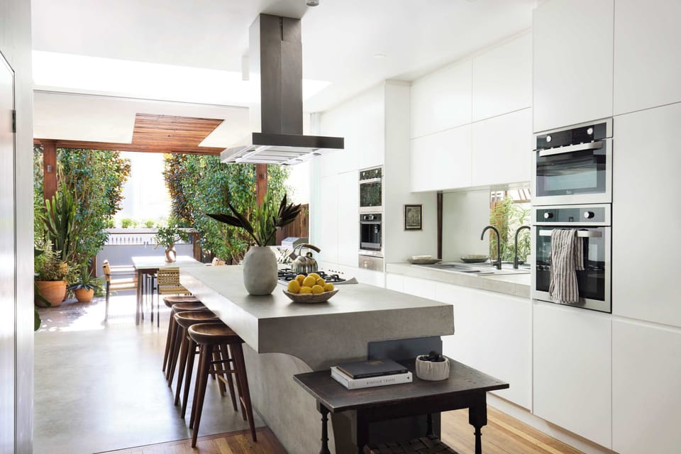 Kitchen with coffee machine, microwave, oven, gas cook top and 6 stools